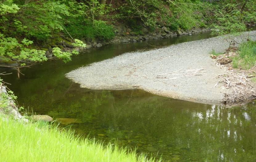 The meandering channel of the Bonnell Creek, Nanoose, BC. The stream is flowing toward the viewer. The sand and gravel point bar must have formed when the creek was higher and the flow faster than it was when the photo was taken, as the current stream velocity is too low to carry such coarse sediments. Most erosion and deposition take place during flooding events. Source: Steven Earle (2015) CC BY 4.0 [view source](https://opentextbc.ca/geology/wp-content/uploads/sites/110/2015/08/Bonnell-Creek.jpg)